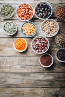 Süper yemek. Kırsal bir arka planda tohumlar ve fasulye çeşitleri. Üst görünüm kopyalama alanı. Vejetaryenler.