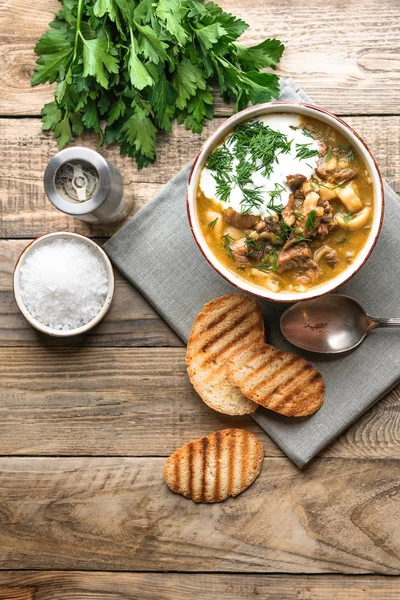 Homemade soup with porcini mushroom, sour cream and herbs on a light rustic background copy space top view.