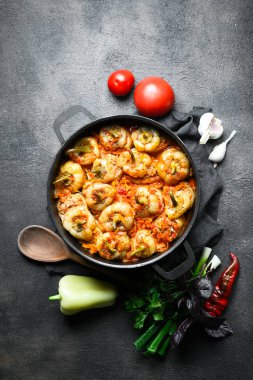 Pilav, et ve baharatla doldurulmuş biberler koyu bir arka plan manzarasında, karanlık bir tavada.