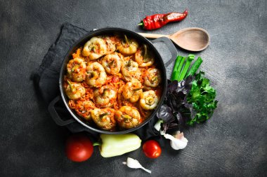 Pilav, et ve baharatla doldurulmuş biberler koyu bir arka plan manzarasında, karanlık bir tavada.