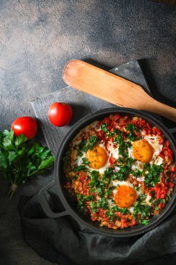 Demir bir tavada yumurta, domates ve maydanozlu Shakshuka. Üst görünüm kopyalama alanı
