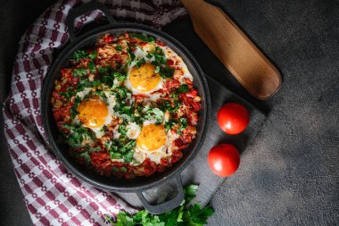 Demir bir tavada yumurta, domates ve maydanozlu Shakshuka. Üst görünüm kopyalama alanı
