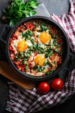 Demir bir tavada yumurta, domates ve maydanozlu Shakshuka. Üst görünüm kopyalama alanı