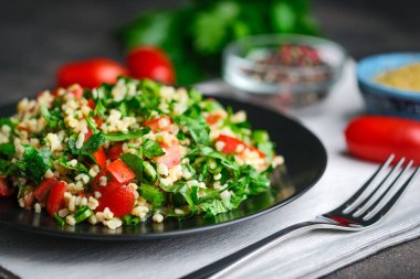 Geleneksel oryantal salata Tabbouleh bulgur ve maydanozlu koyu arkaplan.