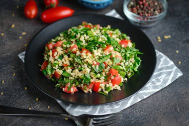 Geleneksel oryantal salata Tabbouleh bulgur ve maydanozlu koyu arkaplan.