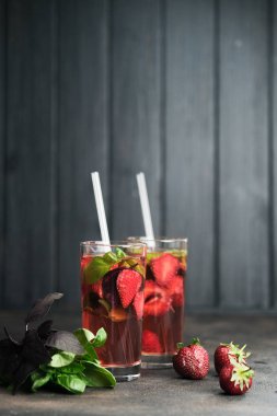 Koyu arkaplanda fesleğen yapraklı taze çilekli limonata..