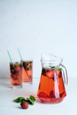 Açık arkaplanda fesleğen yapraklı taze çilekli limonata..