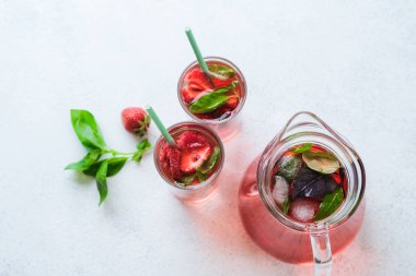 Arka planda hafif bir fotokopi alanında fesleğen yapraklı ev yapımı taze çilekli limonata. Üst görünüm.