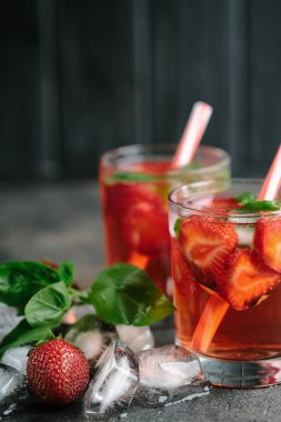 Koyu arkaplanda fesleğen yapraklı taze çilekli limonata..