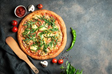 Geleneksel İtalyan pizzası jambon, mozzarella, fesleğen, roka ve domatesli koyu arka planda fotokopi alanı.