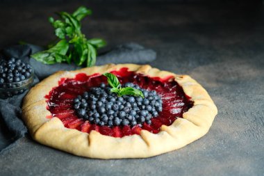 Ev yapımı destek. Erikli ve yaban mersinli leziz galet koyu arkaplan fotokopi alanı.
