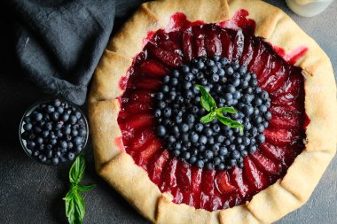 Ev yapımı destek. Erikli ve yaban mersinli leziz galet koyu arkaplan fotokopi alanı üst görünümü