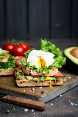 Avokado ve haşlanmış yumurtalı, yeşil yapraklı ve domatesli lezzetli sandviç. Sağlıklı kahvaltı.. 