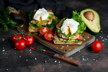 Avokado ve haşlanmış yumurtalı, yeşil yapraklı ve domatesli lezzetli sandviç. Sağlıklı kahvaltı.. 