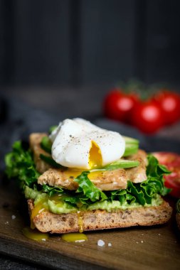 Avokado ve haşlanmış yumurtalı, yeşil yapraklı ve domatesli lezzetli sandviç. Sağlıklı kahvaltı.. 