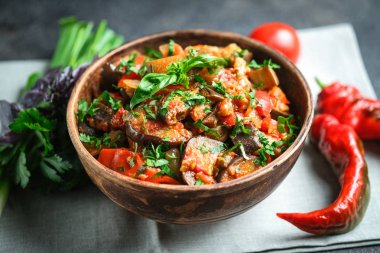 Sebze sote ya da caponata, ya da patlıcan, biber, domates ve otlarla dolu siyah arka planda kırsal bir kase.. 