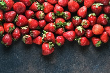 Koyu arkaplandaki taze çilekler.