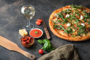 Geleneksel İtalyan pizzası, jambon, mantar, roka, mozzarella, fesleğen ve domatesli koyu arkaplan fotokopi alanı..