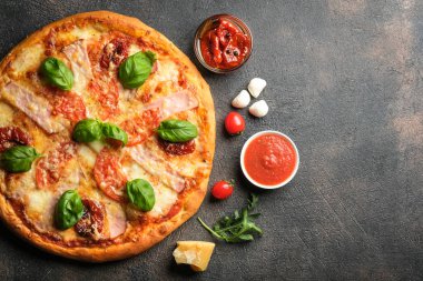 Geleneksel İtalyan pizzası jambon, mantar, roka, mozzarella, fesleğen ve domatesli koyu arkaplan manzaralı..