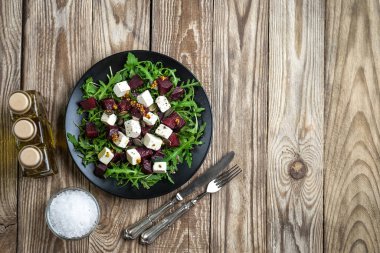 Pancar salatası, peynir, roka ve arka plan manzaralı baharatlı sos. Sağlıklı yiyecekler. Üst Manzara. Boşluğu kopyala.