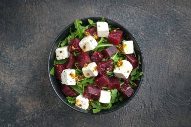 Pancar salatası, peynir, roka ve arkaplan manzaralı baharatlı sos. Sağlıklı yiyecekler. Üst Manzara. Boşluğu kopyala.