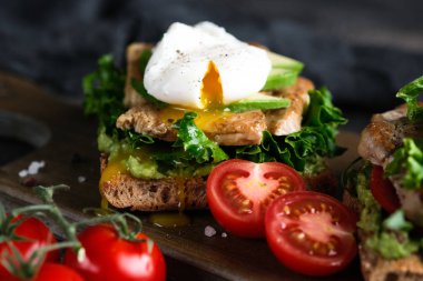 Avokado, haşlanmış yumurta, vişneli domates ve roka soslu lezzetli sandviç.. 