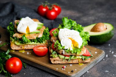 Avokado, haşlanmış yumurta, vişneli domates ve roka soslu lezzetli sandviç.. 