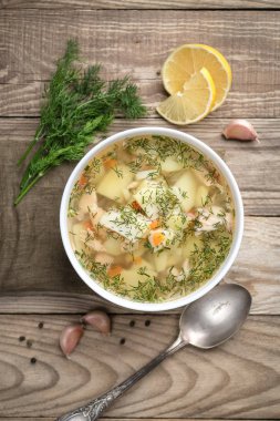 Ev yapımı taze balık çorbası, sebzeler kabın içinde, ahşap arka planda, fotokopi alanı olan üst manzara..