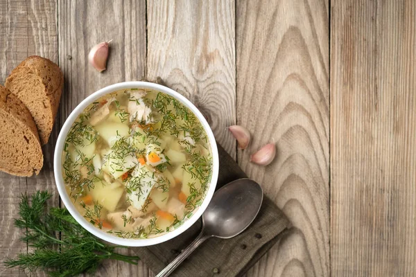 Ev yapımı taze balık çorbası, sebzeler kabın içinde, ahşap arka planda, fotokopi alanı olan üst manzara..