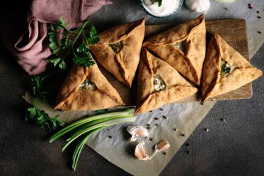 Üçgen et ya da patates, ekşi krema, soğan, sarımsak ve baharatlı tavuk turtası. Echpochmak Tatar geleneksel yemeği. Üst görünüm.