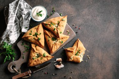 Üçgen et ya da patates, ekşi krema, soğan, sarımsak ve baharatlı tavuk turtası. Echpochmak Tatar geleneksel yemeği. Üst görünüm.