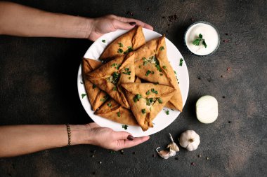 Üçgen et ya da patates, ekşi krema, soğan, sarımsak ve baharatlı tavuk turtası. Echpochmak Tatar geleneksel yemeği. Üst görünüm.