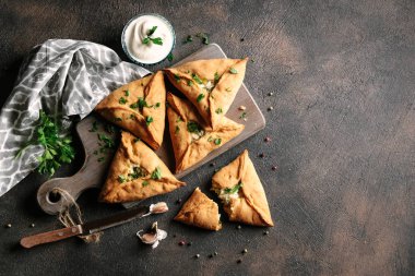 Üçgen et ya da patates, ekşi krema, soğan, sarımsak ve baharatlı tavuk turtası. Echpochmak Tatar geleneksel yemeği. Üst görünüm.