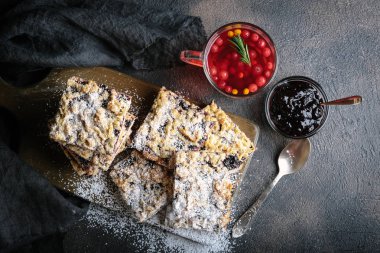 Ev yapımı kısa hamurlu meyveli turta ve koyu arka planda bir fincan çilek çayı. Çay saati için reçelli ev yapımı pasta. Üst Manzara. Boşluğu kopyala.