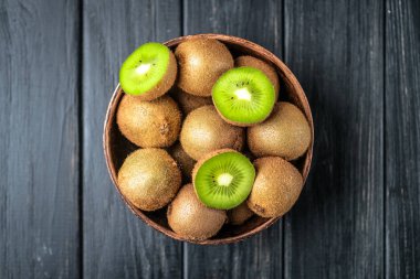 Koyu arkaplanda olgun taze kivi meyveleri. Kopyalama alanı olan üst görünüm.