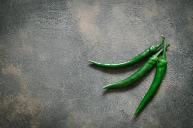 Fotokopi alanı olan koyu arkaplanda yeşil biberler