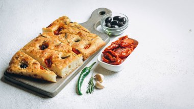 Domatesli, zeytinli ve biberiyeli geleneksel İtalyan Focaccia ev yapımı Focaccia..