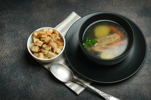 Hearty lunch. Meat broth or bouillon  from veal with breadcrumbs on a dark background.