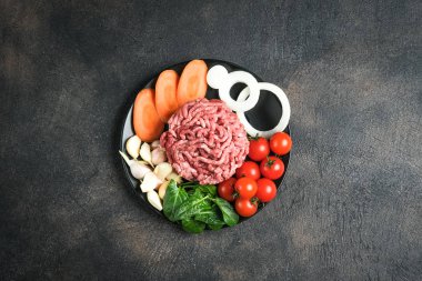 Kıyma. Paramparça et ve malzeme. Arka planda pişirmek için taze sebze ve baharat. Boş kopyalama alanı.