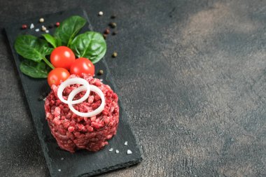 Kıyma. Paramparça et ve malzeme. Arka planda pişirmek için taze sebze ve baharat. Boş kopyalama alanı.