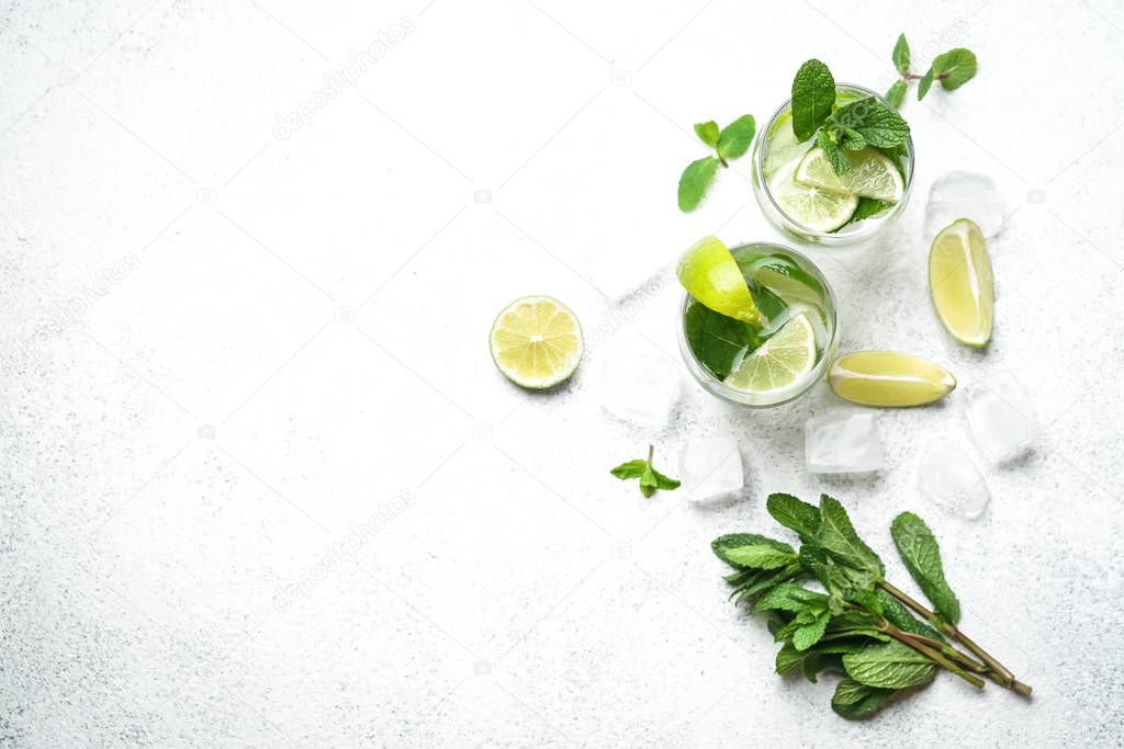 Refreshing mojito cocktail  with mint, rum and lime, cold drink or beverage with ice on white background, top view