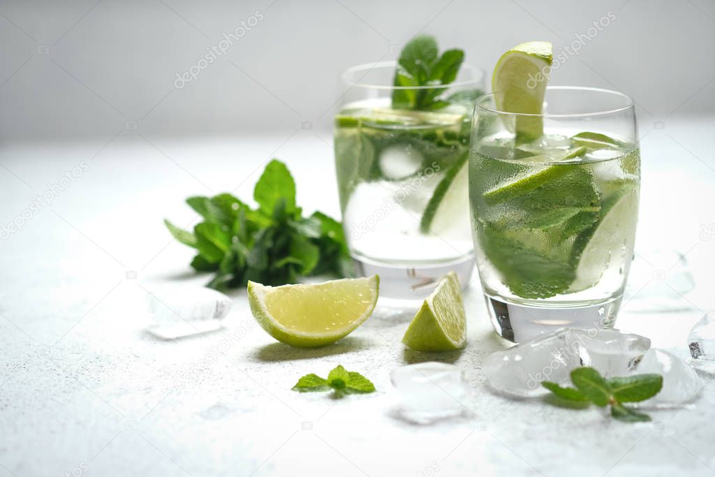 Refreshing mojito cocktail  with mint, rum and lime, cold drink or beverage with ice on white background.