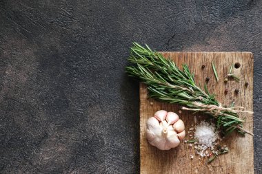 Siyah bir arka planda bir demet taze biberiye ve sarımsak..