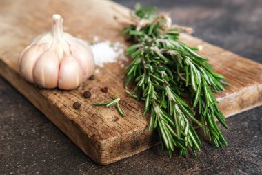 Siyah bir arka planda bir demet taze biberiye ve sarımsak..