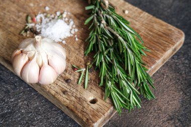 Siyah bir arka planda bir demet taze biberiye ve sarımsak..