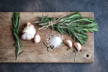 Siyah bir arka planda bir demet taze biberiye ve sarımsak..