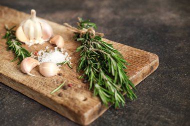 Siyah bir arka planda bir demet taze biberiye ve sarımsak..