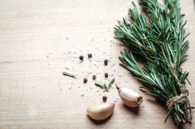 Siyah bir arka planda bir demet taze biberiye ve sarımsak..