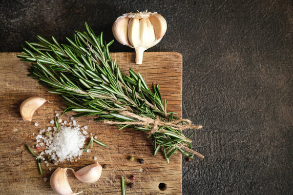 Bunch of fresh rosemary and garlic on a black background.Top view with copy space.