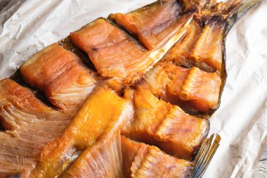 Kırsal arka planda el işi kağıdında füme balık. Yakın plan..